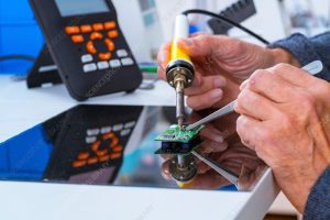 Person soldering an electronic component